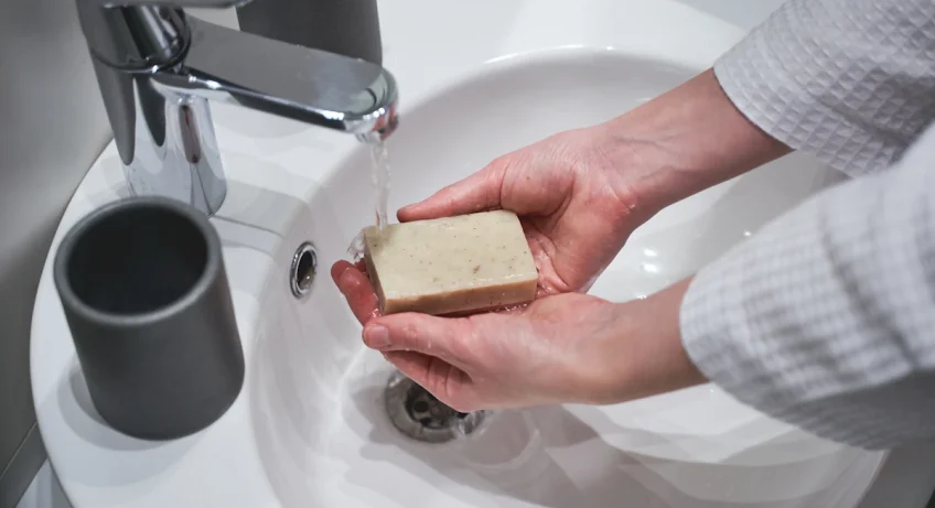 Une personne qui se lave la main avec un savon
