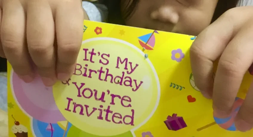Un enfant qui montre une carte d'invitation d'anniversaire