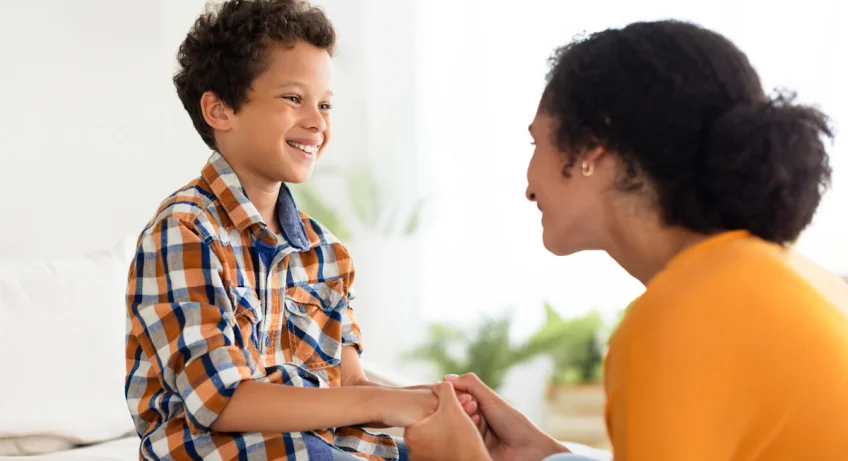 Une femme qui discute en souriant avec un petit garçon